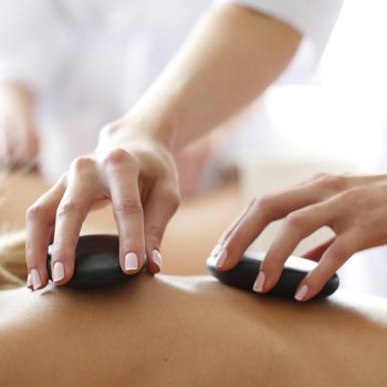 Young beautiful woman in spa getting hot stone massage